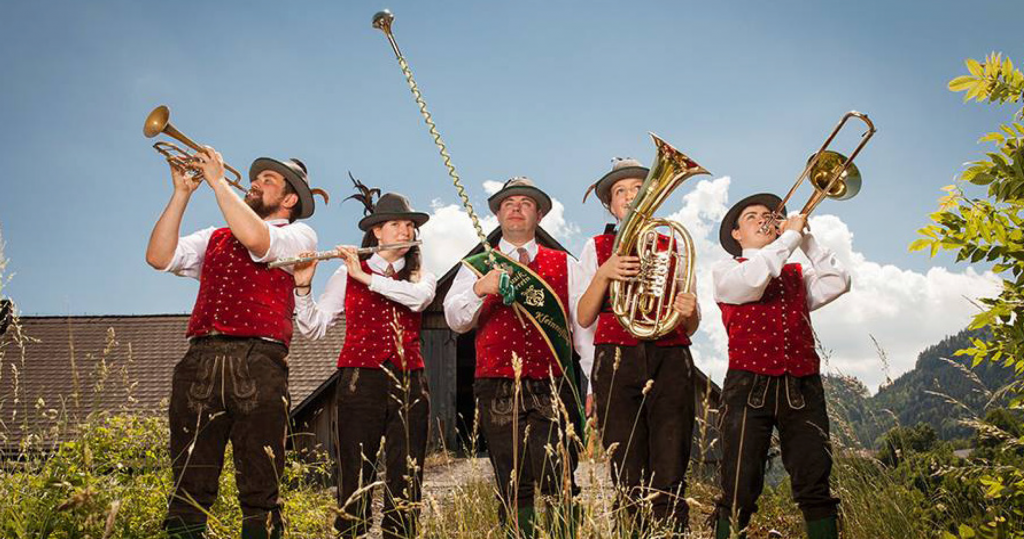 M Fünf Musiker des Vereins stehen im hohen, sommerlichen Gras